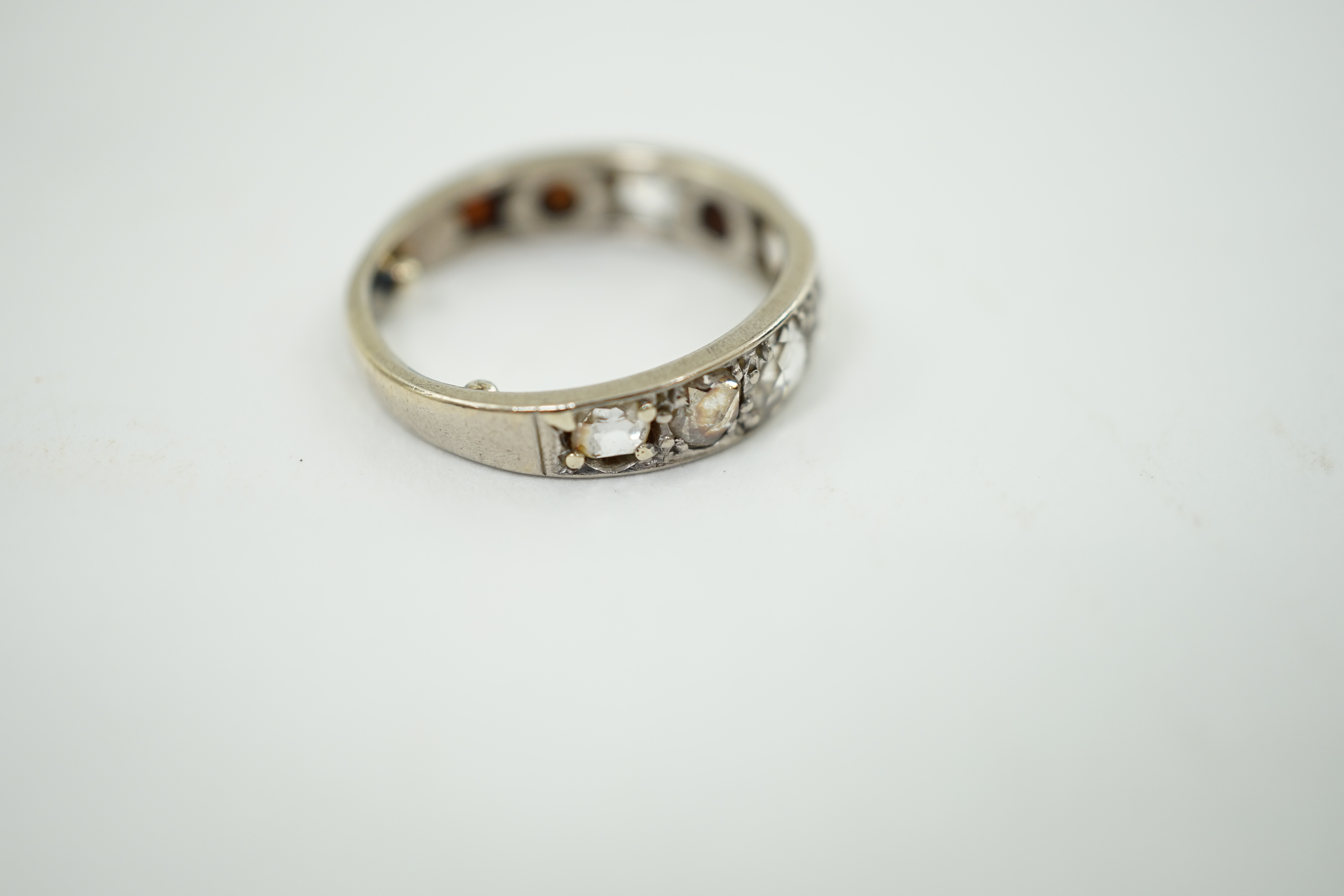 A white gold and nine stone graduated rose cut diamond set half hoop ring